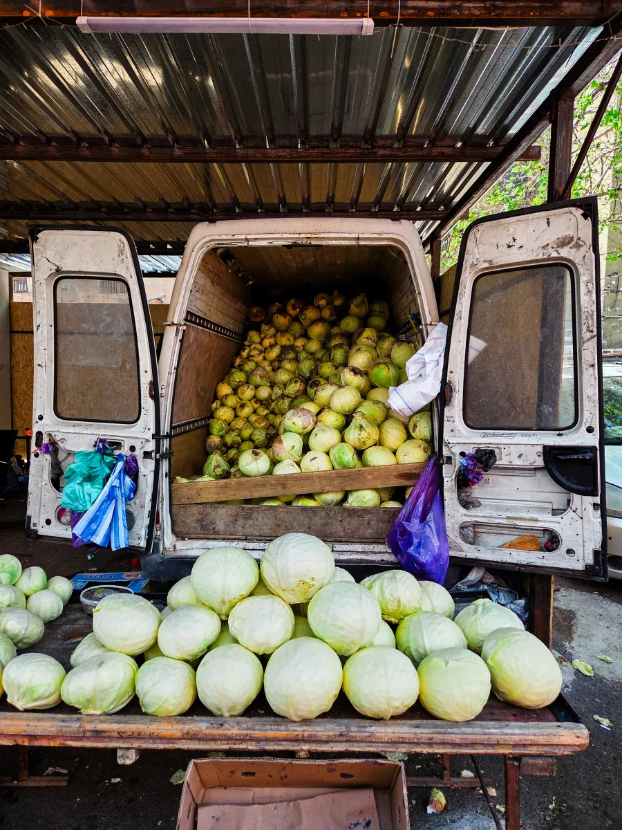 Produce truck full of cabbages and quinces at a market